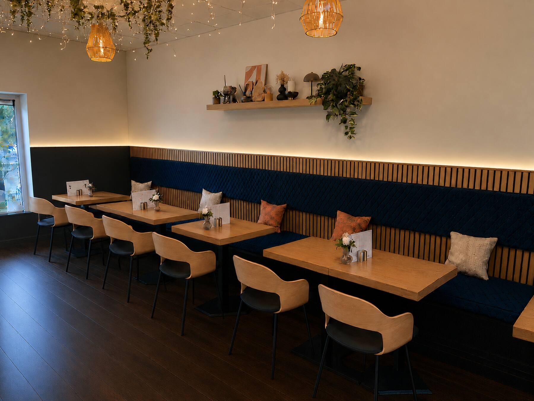 Inside The Olive Cafe: oak tables, a navy banquette and warm lights