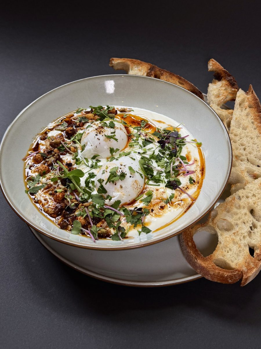 Turkish eggs: poached eggs on garlicky Greek yogurt with spiced butter, herbs and sourdough